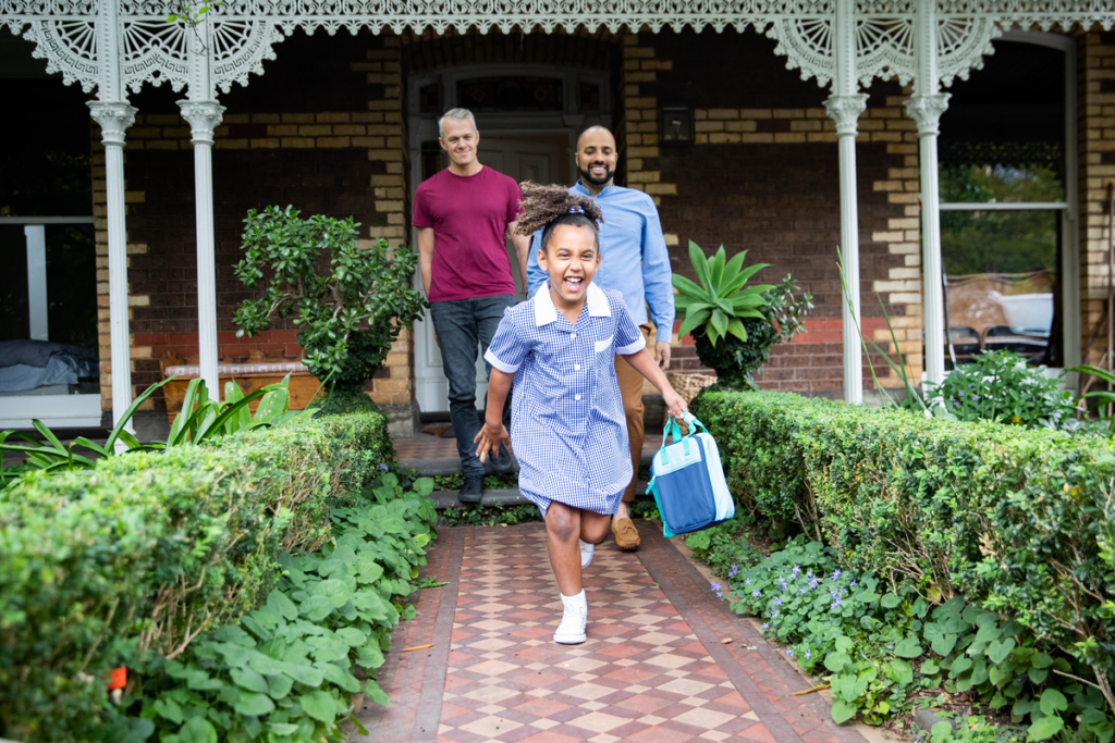Two husbands taking their daughter to school