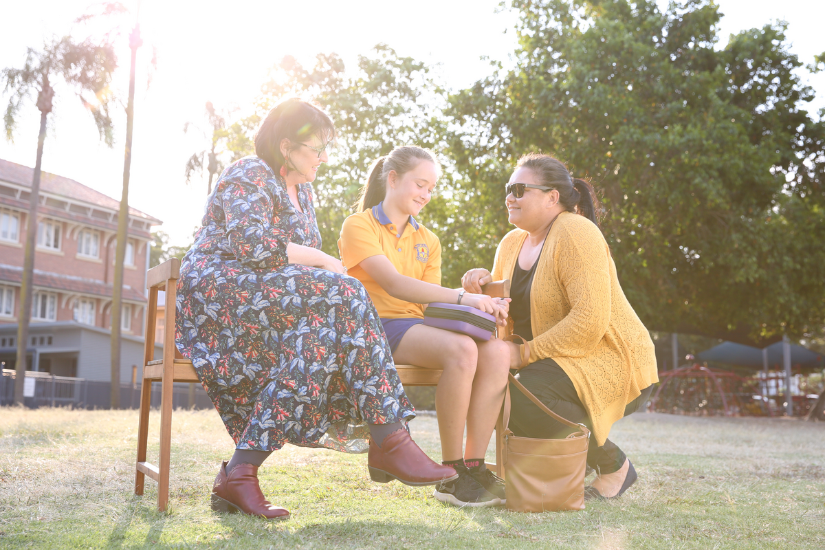 Teacher, student and parent sitting outside